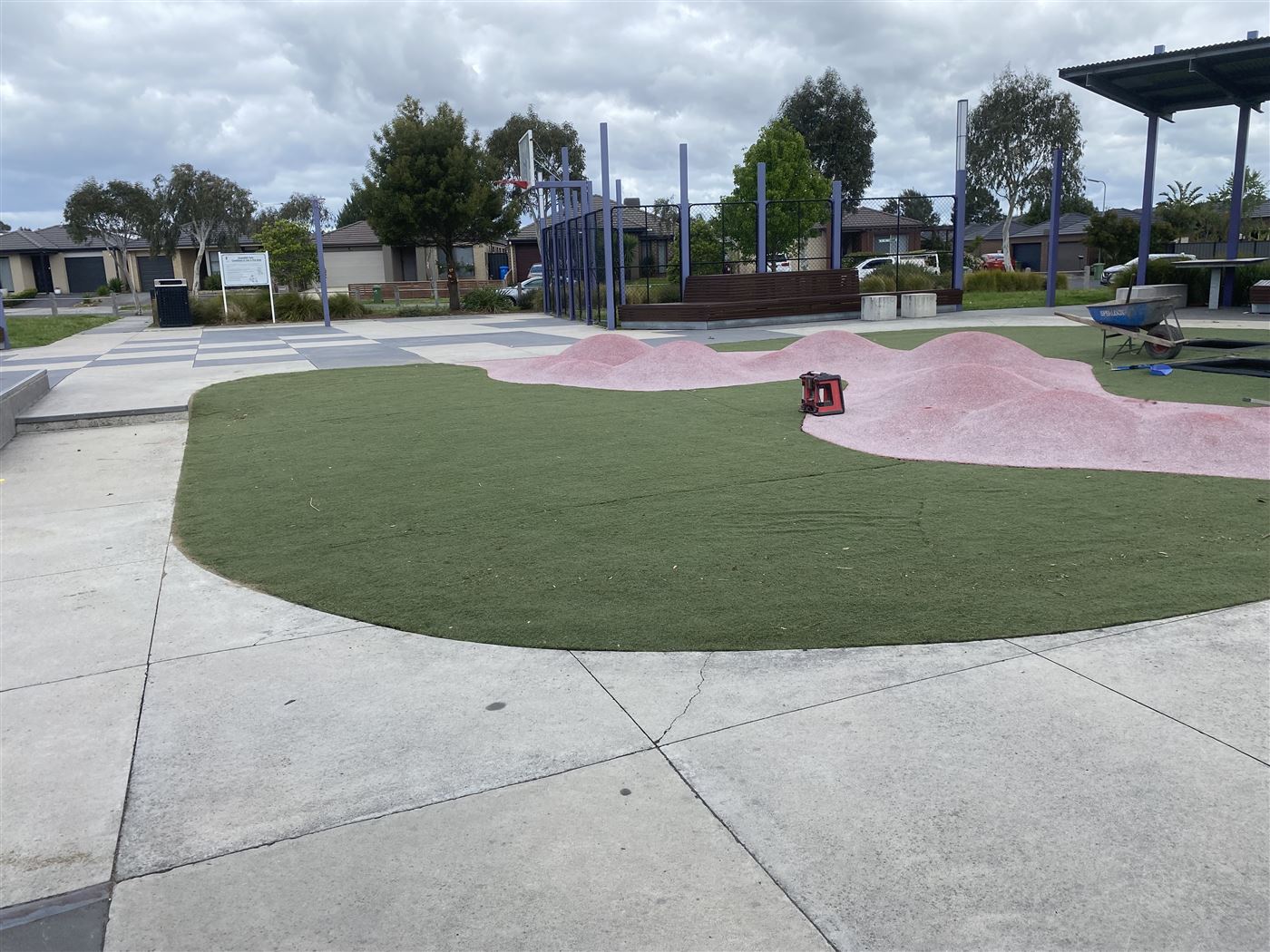 Public playground with synthetic turf mounds, softfall surfacing and plaza paving, built by Sunnybank Horticultural